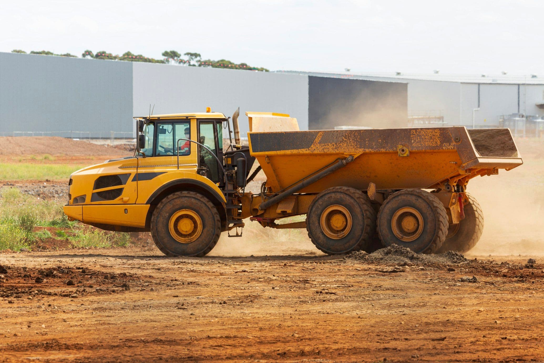 Tipper lorry unloading aggregate on a construction site