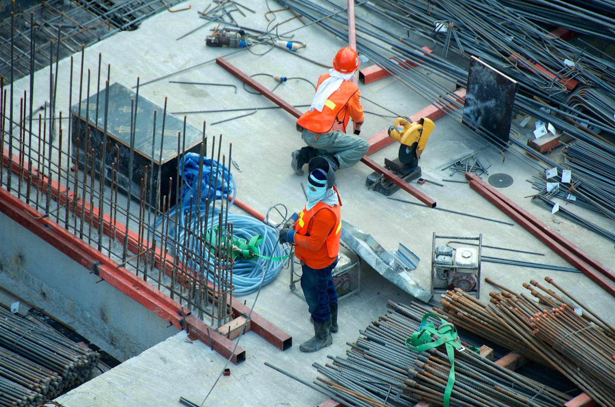Construction workers reviewing structural plans on an active high-rise site